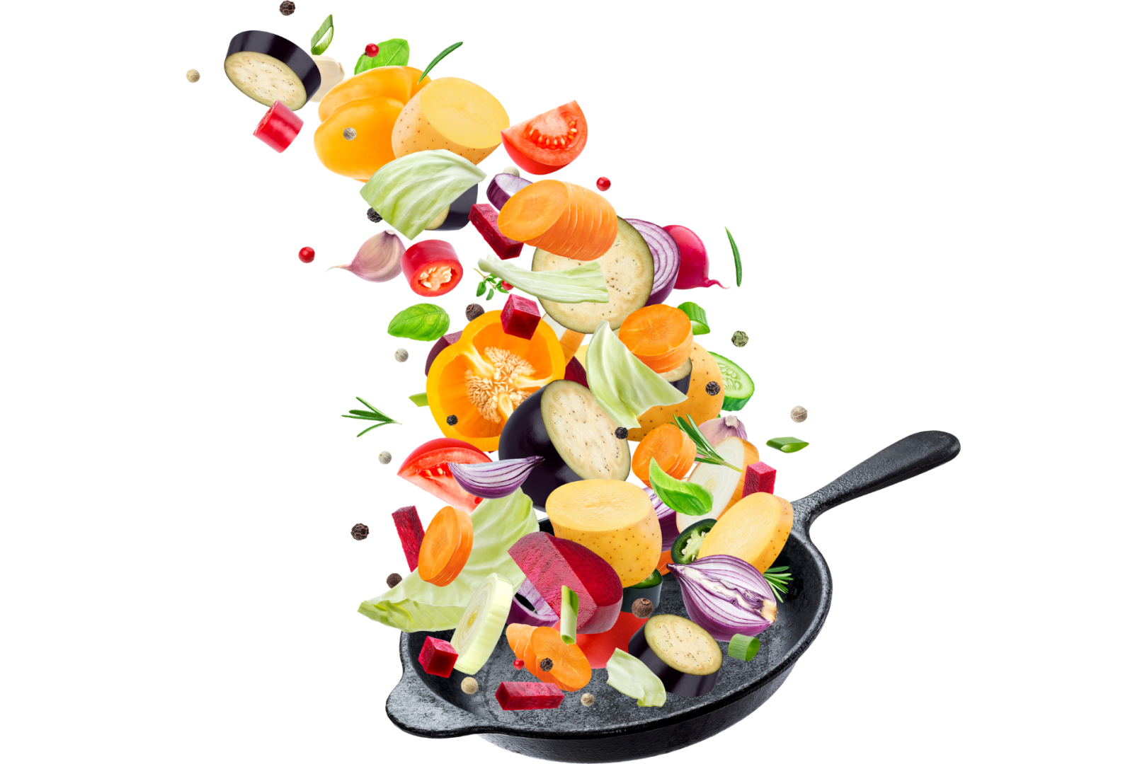 A black skillet with chopped fruits and vegetables that appear to be flying into it.